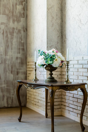 Decorated vintage table in white baroque style interior with red luxury sofa. Table is set for romantic event.の写真素材