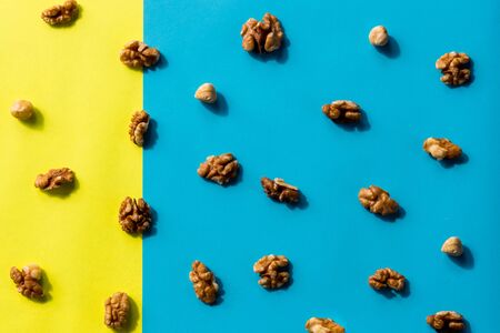 Isolated nuts pattern backdrop. Walnut, cashew, almond and hazelnut on colorful background. Top view.Flat lay composition of different nuts and nuts on yellow blue background.の写真素材