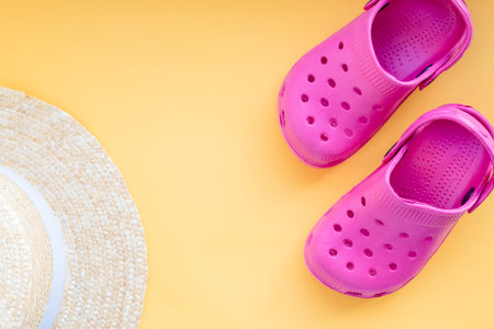 Summer beach bag with straw hat,towel,sunglasses and flip flops on sandy beach