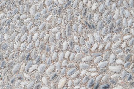 White pebble in concrete path. Top view stone background. Seaside pebble photo texture. Stone paving surface. White marbles flat lay background. Natural outdoor decor material.rounded cobbles set into street walkway.の素材 [FY310135354919]