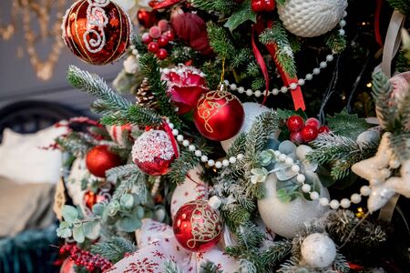 Modern christmas tree, decorated with vintage ornaments, ratan balls, burlap and tartan ribbons, wooden snowflakes, red berries and balls, red white balls.Christmas baubles.Merry christmas card. Winter holiday theme. Happy New Year.の写真素材