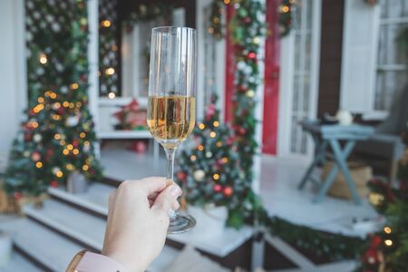 toast with glass of champagne in female hand.New Years Eve celebration.party, drinks, holidays, people and celebration concept.Champagne and new year decoration.Party with sparkling wineの写真素材