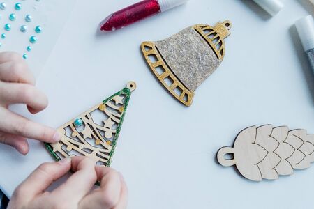 Workshop, girl mades a wooden christmas ornaments. Material for creativity. Step-by-step master class. wooden Toy for decorating the Christmas tree.Creative diy hobby. handmade craft, stylish Christmas decorationの写真素材