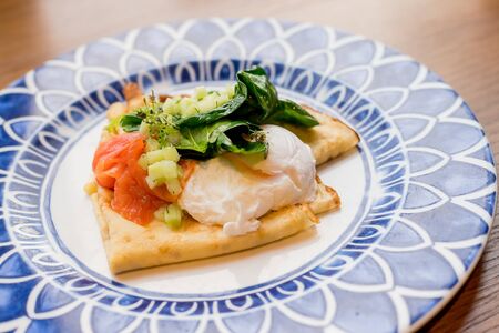 Savory crepes with salmon and poached egg.Tasty breakfast with pancakes, smoked salmon, pouched egg with spinach,Lettuce, onion, Hollandaise sauce.Fresh, healthy breakfast .の写真素材