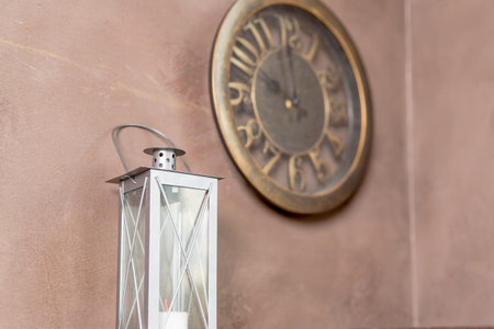 interior of the room in the style of steampunk, lantern,iron details. Antique Clock Isolated on beige Wall Background. Vintage Retro Clock, Decorative Old Fashioned Interior Design Element. loft styleの写真素材