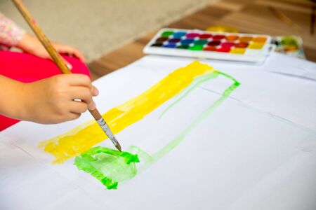 Preschool children, little girl painting and drawing.Child painting in the kindergarten.Child holding a paintbrush and working on a painting for art class.art school, creativity and people conceptの写真素材