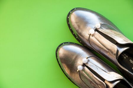 Trendy new collection of glamorous fashionable boots. Close-up of female silver stylish sneakers with gray fur outdoors.の写真素材