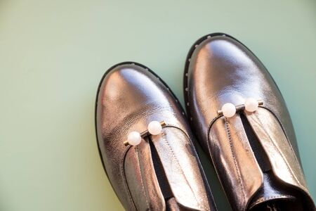 Trendy new collection of glamorous fashionable boots. Close-up of female silver stylish sneakers with gray fur outdoors.の写真素材