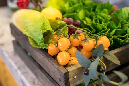 fresh Organic vegetables in the box in shop. Healthy Organic Vegetables.Assorted vegetables in wooden box. summer harvest, healthy food for healthy living.delicious yellow tomatoes, salad.の写真素材
