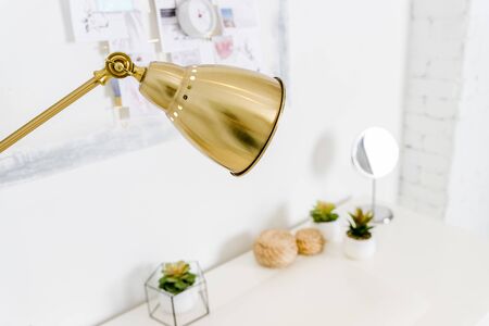 golden Lamp ,table lamp, paperwork and stationery items on white table.の写真素材