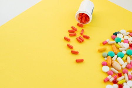 Pharmaceutical medicine pills.Pills in medicine bottle on yellow background.Vitamins supplements....