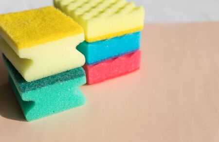 Brightly colored sponges on beige background with copy space.Bright colored sponges for washing dishes, cleaning the bathroom and other household needs.Cleaning sponge.household conceptの写真素材