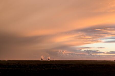 Smoking chimneys power station on sunset.Factory pipe polluting air against sunset, ecology. Heavy industrial air pollution from smokestacks. Factory chimney blowing pollution in environment.の写真素材