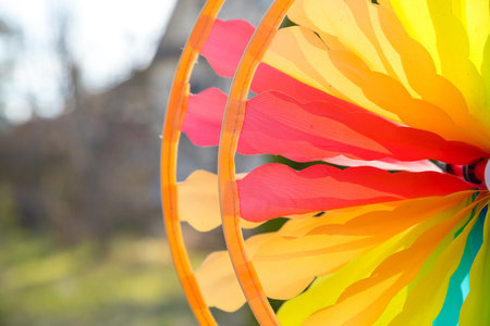 Colorful pinwheel spinning in the wind in front of a natural green background.focus on center of...