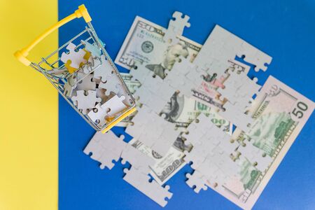 Shopping cart full of jigsaw puzzle on money dollar background, Business solution concept ,key for success,Flat Layの写真素材