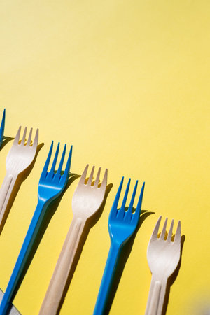 Flat lay photo comparison between disposable foam food container and plastic cutlery and reusable...
