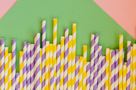 Drinking straws for party on white background. Top view of colorful paper disposable eco-friendly straws for cocktails.の写真素材