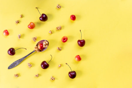 Healthy breakfast meals on yellow table, copy space. Cornflakes, muesli, berries and spoon, top...