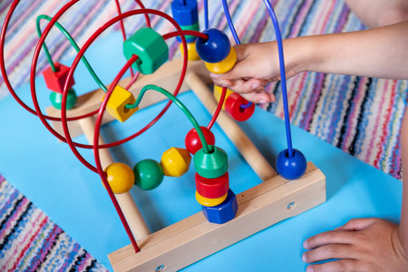 child hand playing and learning with bead roller coaster toy. Selective Focus.Logic toy with paths...