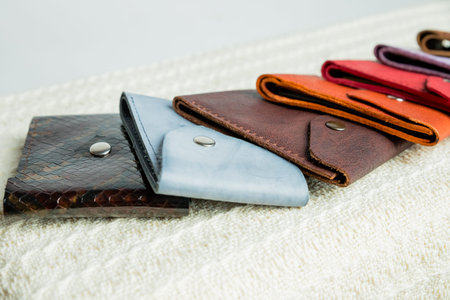 Colorful leather wallets.Leather handmade wallets of different forms lying on a beige textile...