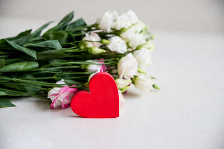 A bouquet of White eustoma flower with a heart on white background. White and pink lisianthus for Valentines day, wedding or mothers day. love concept.Floral still life.Copy spaceの写真素材