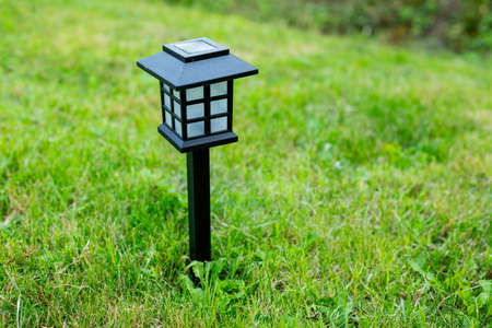Solar cell lamp in garden and save energy of electric and save my world,close up.Charging solar lamp on the ground in the garden at sunny day, renewable energy concept.decorative spot lightの写真素材