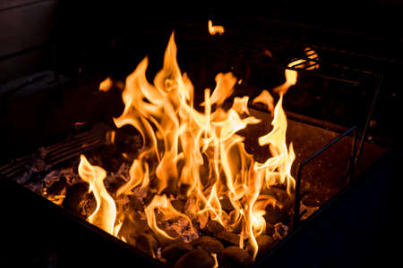 Barbecue Fire Grill on Black Background.burning charcoal. Focus is on Hot coals in the fire.burning charcoal background with fire and sparks.The coals smolder outdoorの写真素材