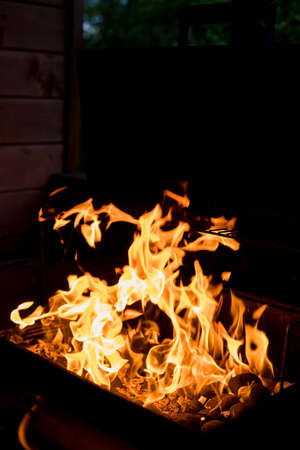 Barbecue Fire Grill on Black Background.burning charcoal. Focus is on Hot coals in the fire.burning charcoal background with fire and sparks.The coals smolder outdoorの写真素材