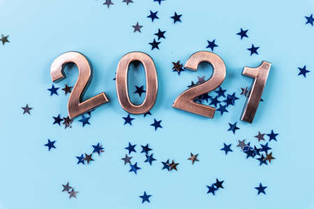 2021 golden figures and colorful stars, confetti on a blue background.Happy New Year celebration. Gold numbers , holiday background, postcard,party.の写真素材