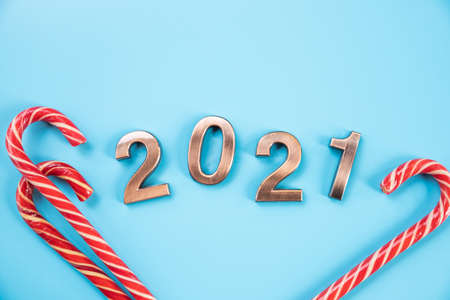 Happy New Year 2021. Shiny numbers, symbol 2021 on blue background. Christmas composition with elements of New Years decor,candy cane. Top view, flat lay.design greeting card. festive styleの写真素材