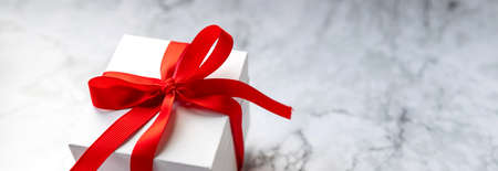 white gift box with red bow on the marble background. Holiday banner for website.Greeting web banner with blue gift box. Pink bows.の写真素材