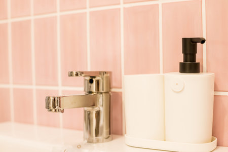 Chrome water faucet with marble counter tops,white sink.Luxury faucet mixer in bathroom. bathtub and...