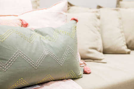 Selection of colorful cushions on a sofa.Decorative pillows.Bedding with a trendy pillows . Copy space.Classic style of cushions and bed in pastel tone colorの写真素材