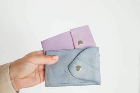 Group colorful Wallet of Leather skin on white background.Two Fashionable modern leather pouch wallets in hand, close up, brass snaps, neutral colors.Trend accessories.の写真素材