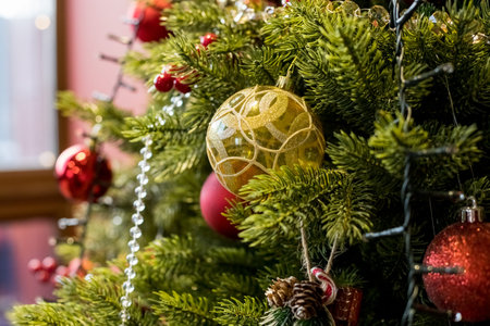 Christmas baubles on christmas tree. Warm light.