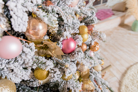 Christmas tree decorated with toys in gold and pink color. Christmas ornaments,ribbons, stick figure deer, beads and lights glowing garland. Winter Holiday.Luxury new year decor.の写真素材