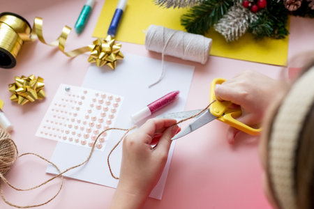 the child makes a New Year card for the winter holidays. DIY crafts and crafts for Christmas do-it-yourself concept.Creating a greeting card.winter holidays.Fine motor skills, creativity development.の写真素材