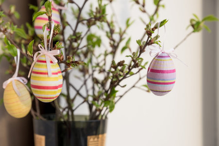 Easter eggs hanging on a spring blossom branch. Easter decorations. Birch tree branches decorated...