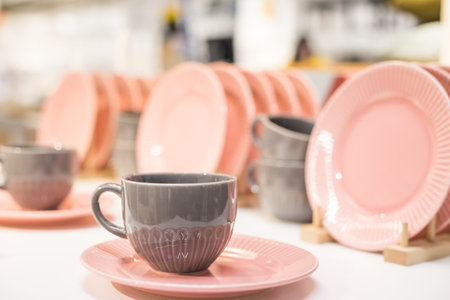 Commercial pink and white plates and bowls stacked with crystal wine glasses.Colorful ceramic clean dishware.Ceramic crockery tablewareの写真素材