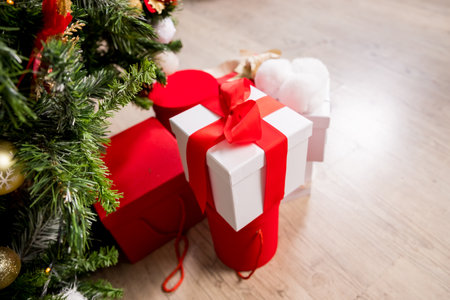 Different Christmas presents with handmade decoration.Wrapped in red paper present boxes under christmas tree. New year tree with ornaments and garland. Winter holiday background.many gifts.の写真素材
