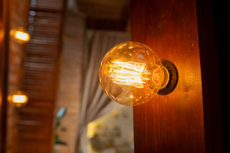 Old glowing light bulbs on dark background.Bright glowing clear glass lamp pear shaped close up. vintage styled lamp.Lighting decoration. copy space.の写真素材