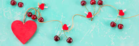 Ripe red sweet cherries with red heart on grungy table. Romantic love concept.Fresh red berries,chery,harvest concept, vitamins food. prevention of cardiovascular diseases. web banner.copy spaceの写真素材
