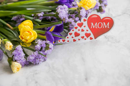 Romantic background with bouquet of Yellow narcissus flowers and purple irises, statice flowers.Happy mothers day concept. copy space.Design concept,Festive compositionの写真素材