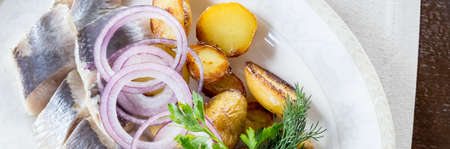 Seafood platter with smoked mackerel slice, fried potatoes, slices fish fillet, decorated with onionの写真素材