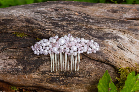 Handmade jewelry. Hair comb made with crystal and rhinestones. The trends in wedding style. Prepare the bride for the ceremony. Selection of jewelry.Beautiful crystal pearl comb on tree bark.の写真素材