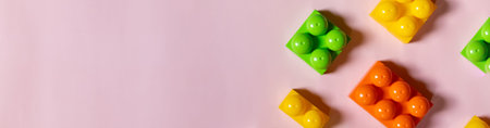 Multicolored plastic kids constructor on blue background. Colored childrens bricks for construction....