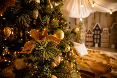 Decorated Christmas tree on blurred, sparkling and fairy background.Festive fir tree branches with shiny golden baubles, balls, xmas ornaments and bright warm lights, garland.の写真素材