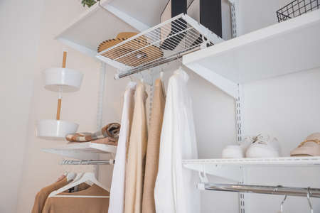 Interior of show room with stylish clothes and accessories.Collection of female clothes hanging on rack in dressing room. room interior with clothing rackの写真素材