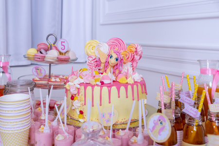 Candy jar and fancy milk bottles for drinks on a dessert table at birthday party or wedding celebration.assortment of sweets. Cake pops.Delicious reception candy bar full with cakes and sweetsの写真素材