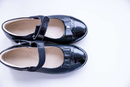 Fashionable black stylish girls leather loafers on white background. Fashionable school shoes.Elegant kids shoes.Top view. Copy spaceの写真素材